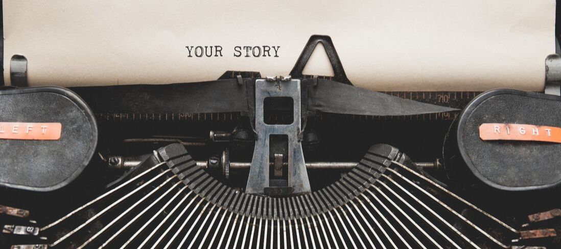 Close-up image of a typewriter with the words YOUR STORY typed on the page